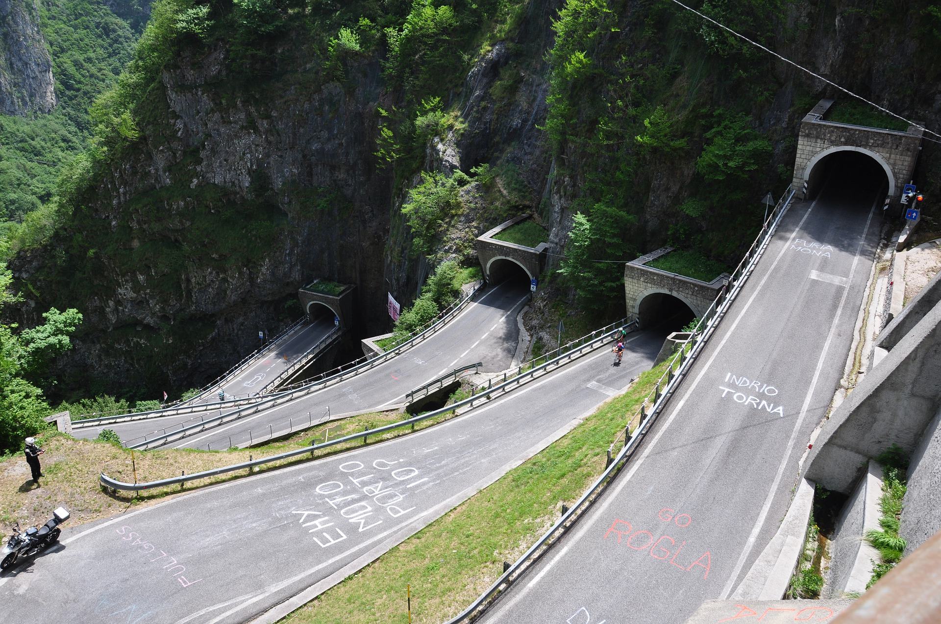 A cyclist riding a winding mountain road near the San Boldo Pass in Italy